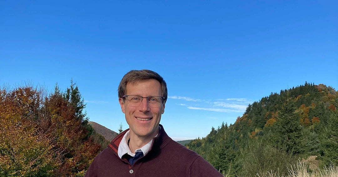 Photo du fondateur avec la chaine de puys en fond d'écran